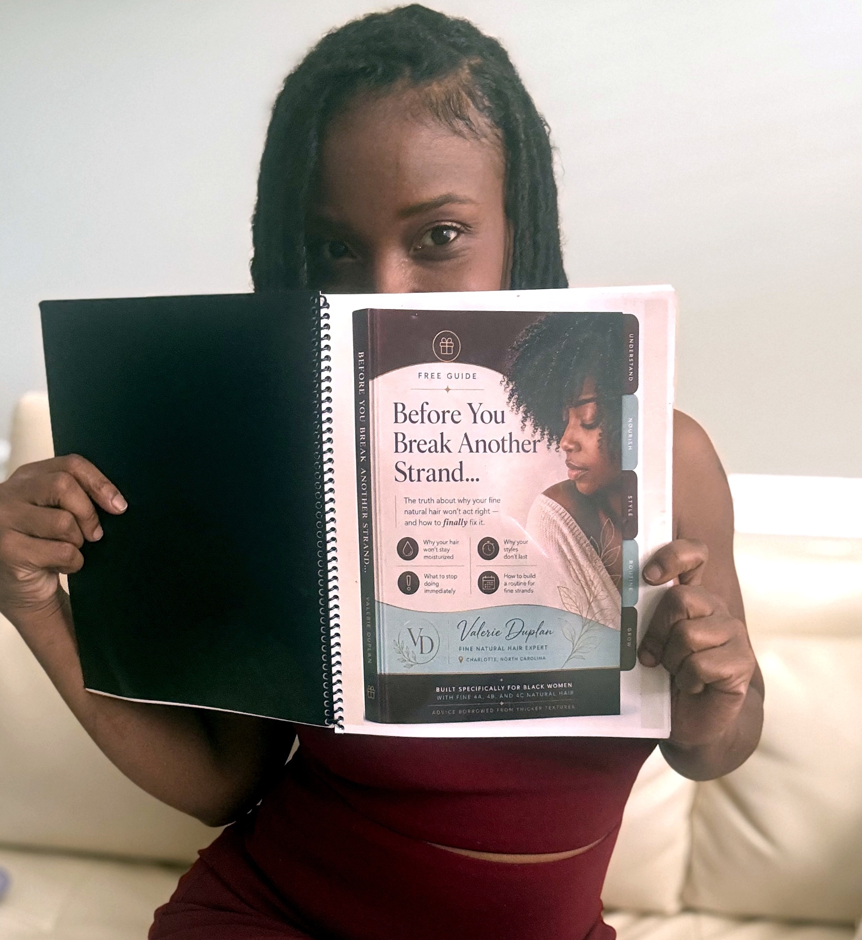 Valerie Duplan holding her free guide, Before You Break Another Strand, open with the cover facing you